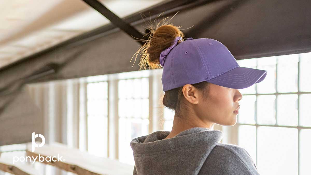 Woman with violet purple ponytail hat with hair in a bun